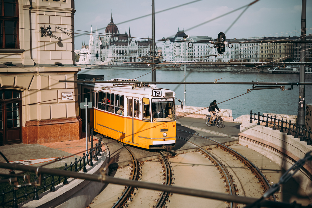 photo of iconic yellow tram in budapest, the river is in the background