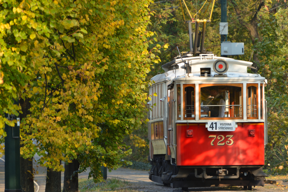 a historic tram surrounded by trees in the beautiful city of prague