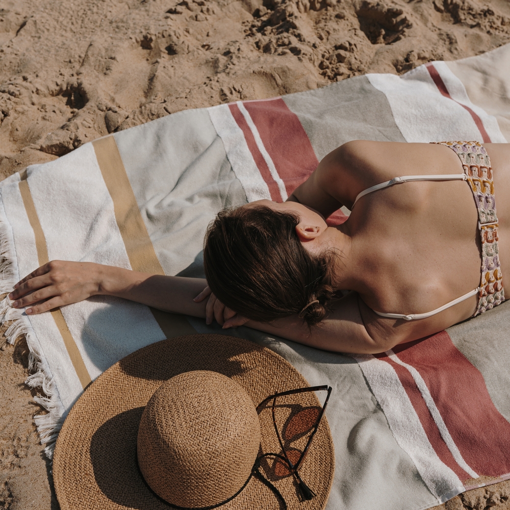 Woman in bikini lays and sunbathing on the beach.