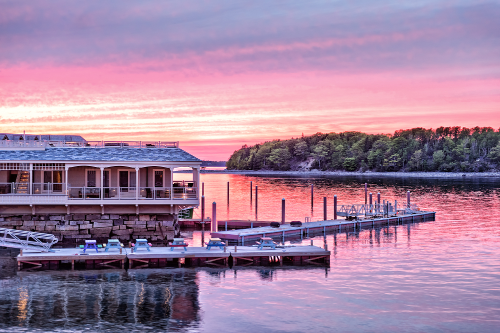 Downtown Bar Harbor village in summer during bright red sunset twilight with waterfront restaurant, pier