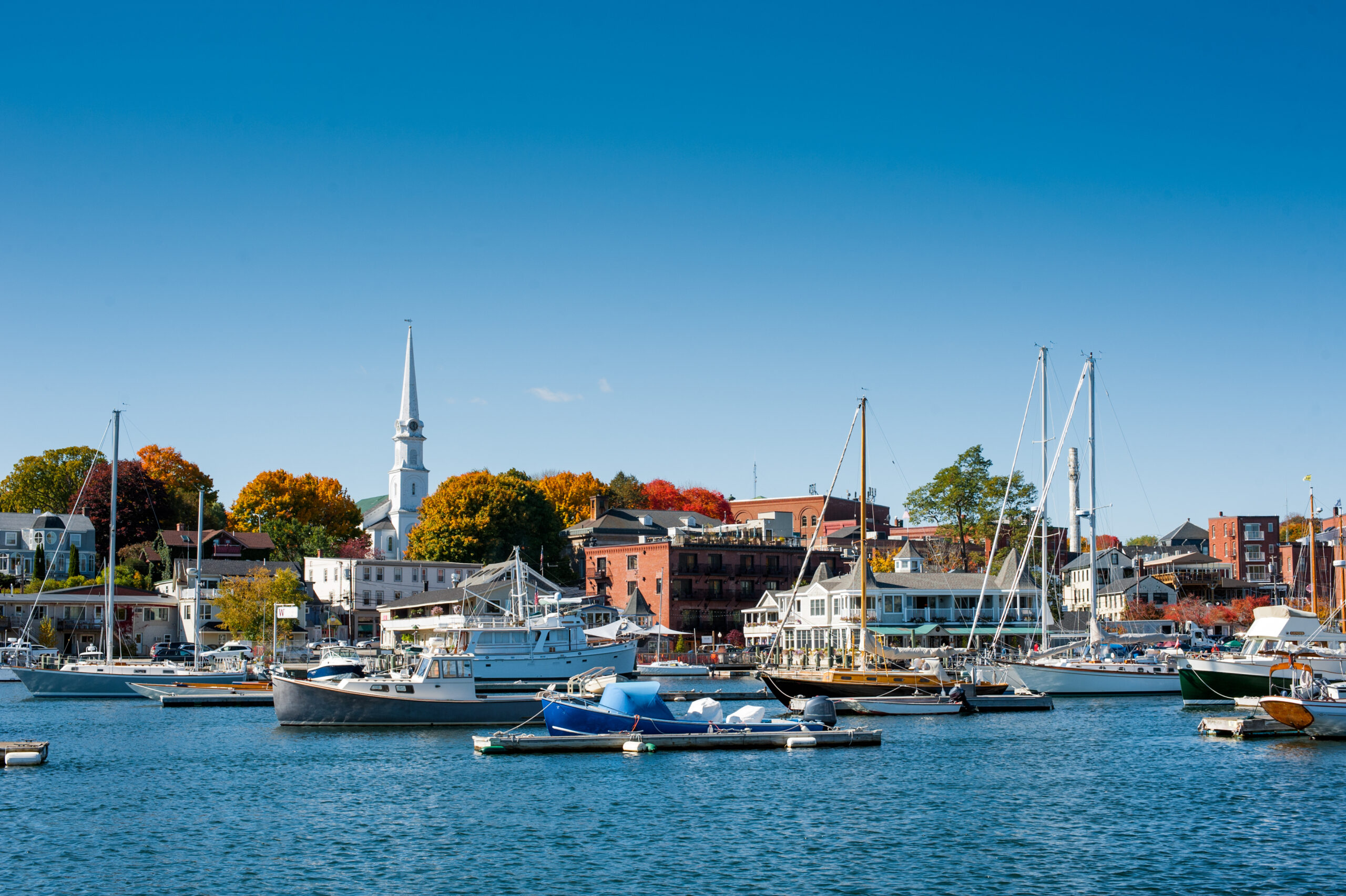 Boats moored in Camden, Maine harbor. The article is about towns in New England that feel like a hallmark movie.