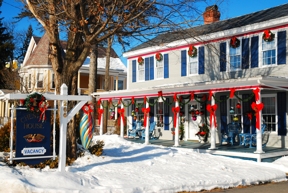 Christmas decorations adorn an an inn in Chester, Vermont during the holiday season. The article is about towns in New England that feel like a hallmark movie.