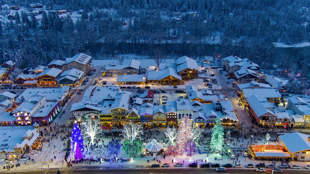 an ariel view of the town ofr Leavenworth with christmas lights ice staking rink and snow covered streets Best christmas vacations in the USA