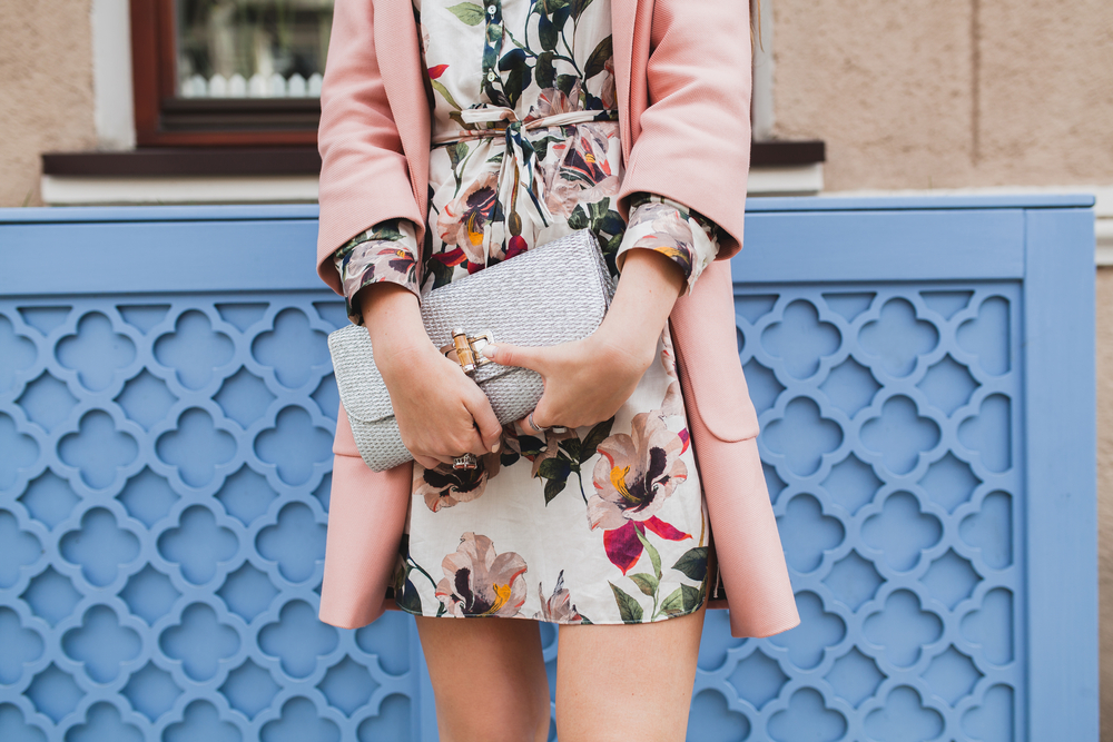 This close up shows that people know What to wear in Italy in spring with their floral dresses, structured purses, and pink fitted blazer.