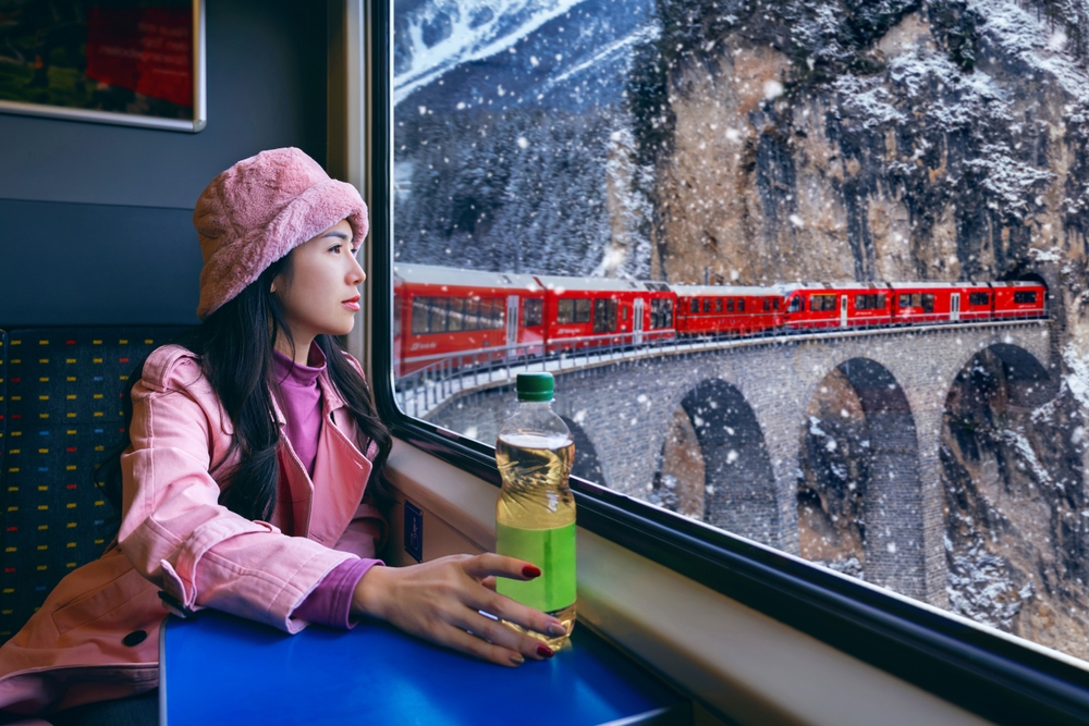 Tourist looking out the window enjoying with Train passing through famous mountain in Switzerland.