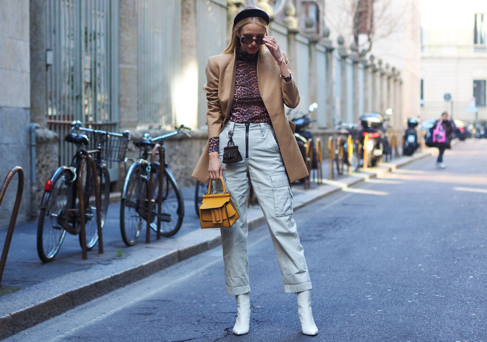 This woman pauses on the street to adjust her sunglasses, knowing full well what to wear in Italy in November in her jeans and comfortable jacket .