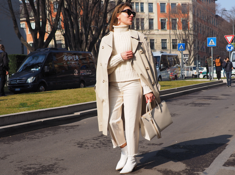 A woman walking down the street knows what to wear in Italy in November with her chinos, boots, turtleneck and sweater that all match!