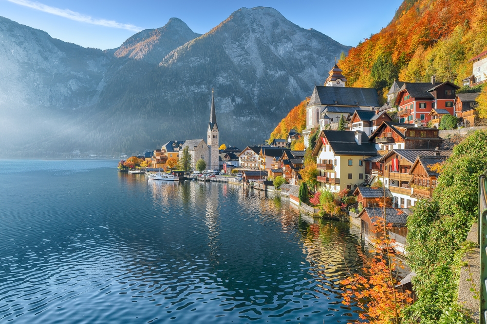 In Northern Europe, which is one place to consider when looking at iconic Europe Trips to Take in 2026,  mountains are on the edge of the lake, as are homes, churches, and the trees that fade into fall covers. 