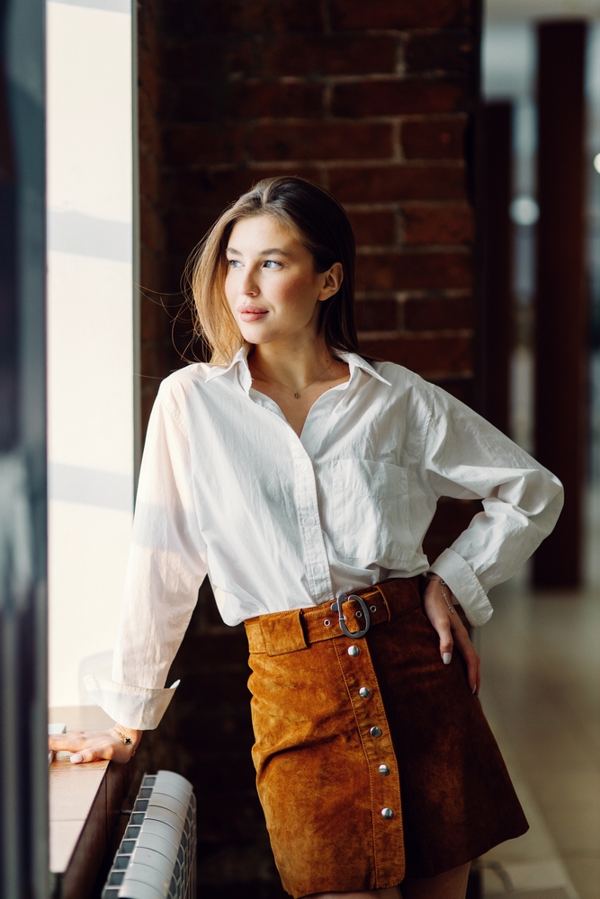 a woman looking chick in skirt and button down